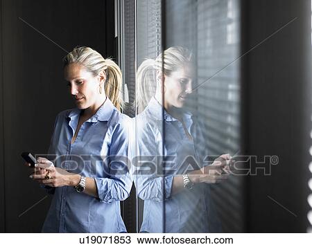 Woman looking at her cellphone View Large Photo Image Stock Image - Woman looking at her cellphone. Fotosearch