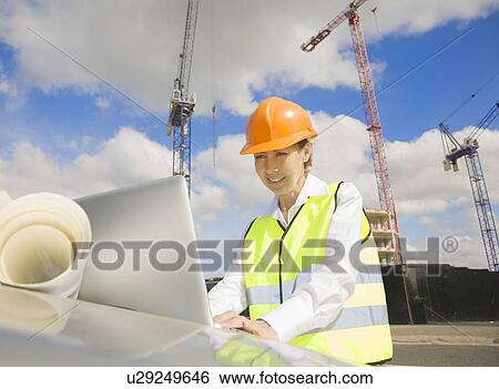 Woman looking at Laptop by Building Site View Large Photo Image Stock Photograph - Woman looking at Laptop by Building Site. Fotosearch