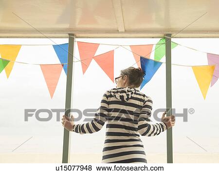 Stock Photo - Woman looking out past bunting. Fotosearch