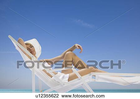 woman lying in a sun lounger View Large Photo Image Stock Image - woman lying in a sun lounger. Fotosearch