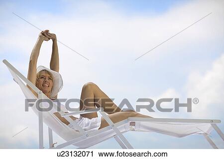 woman lying in a sun lounger View Large Photo Image Stock Image - woman lying in a sun lounger. Fotosearch