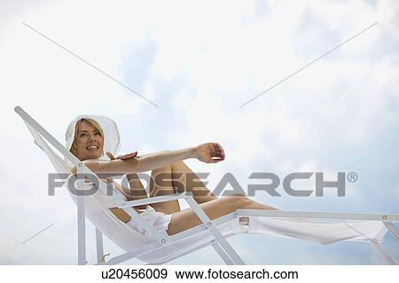 woman lying in a sun lounger View Large Photo Image Stock Photo - woman lying in a sun lounger. Fotosearch