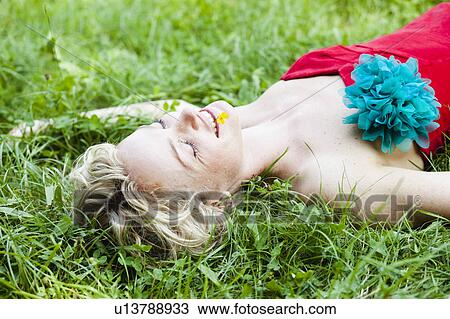 woman lying in grass eyes closed View Large Photo Image Stock Image - woman lying in grass eyes closed. Fotosearch