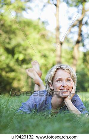 woman lying in grass smiling View Large Photo Image Stock Image - woman lying in grass smiling. Fotosearch