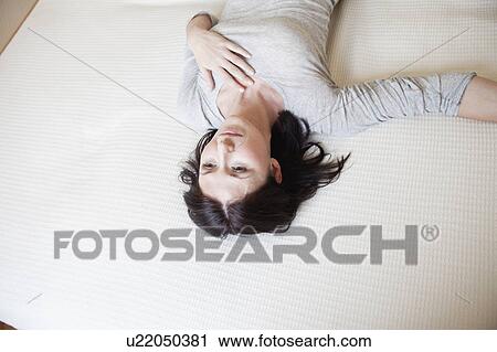 woman lying on bed View Large Photo Image Stock Image - woman lying on bed. Fotosearch