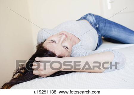 woman lying on bed View Large Photo Image Stock Photo - woman lying on bed. Fotosearch