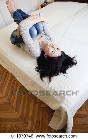 Stock Photograph - woman lying on bed. Fotosearch