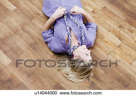 Stock Image - woman lying on floor. Fotosearch