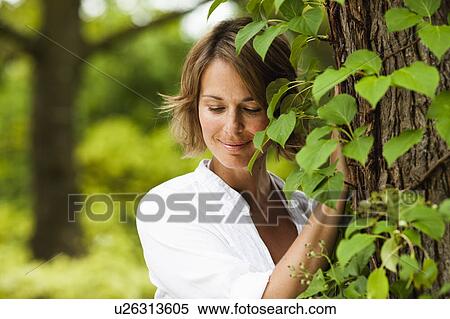 woman next to a tree smiling View Large Photo Image Stock Photography - woman next to a tree smiling. Fotosearch