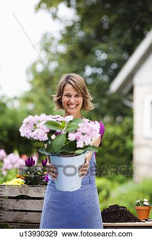 Stock Photo - woman offering a bucket of flowers. Fotosearch