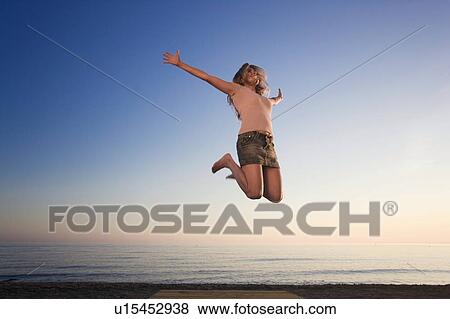 Woman on beach jumping for joy View Large Photo Image Stock Photo - Woman on beach jumping for joy. Fotosearch