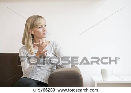 Stock Photo - woman on couch thinking. Fotosearch