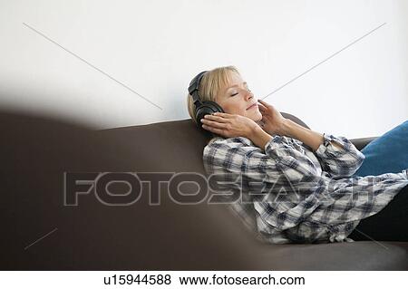 woman on couch with headphones View Large Photo Image Stock Photo - woman on couch with headphones. Fotosearch