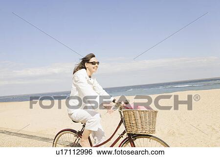 Woman on promenade riding bike View Large Photo Image Stock Photograph - Woman on promenade riding bike. Fotosearch
