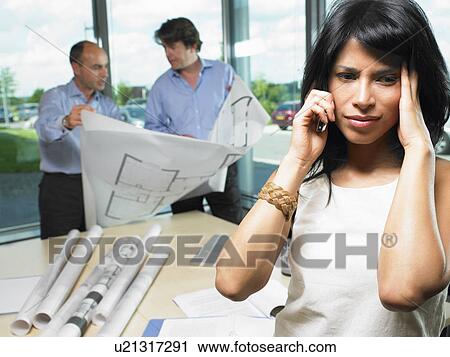 Stock Image - Woman on the phone, men with blue prints. Fotosearch