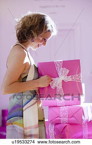 Picture - woman opening presents. Fotosearch