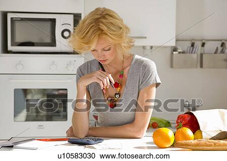 Stock Image - Woman paying bills. Fotosearch