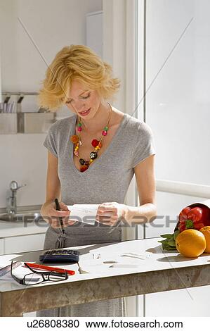 Stock Image - Woman paying bills. Fotosearch