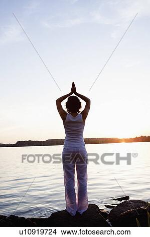 Picture - Woman Performing Yoga At Lakeside. Fotosearch