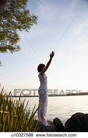 Woman Performing Yoga At Lakeside View Large Photo Image Stock Photo - Woman Performing Yoga At Lakeside. Fotosearch