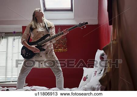woman playing guitar on bed View Large Photo Image Stock Image - woman playing guitar on bed. Fotosearch