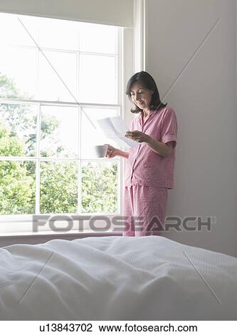 Woman reading letter by window View Large Photo Image Stock Image - Woman reading letter by window. Fotosearch