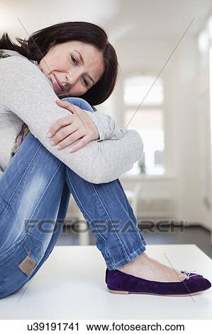 Stock Image - woman resting head on her knees. Fotosearch
