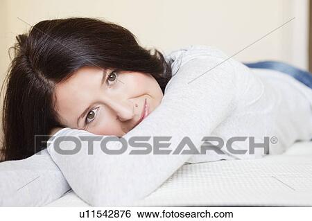 woman resting on bed smiling View Large Photo Image Stock Photograph - woman resting on bed smiling. Fotosearch