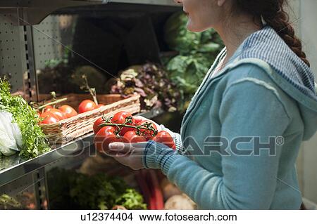 Picture - woman shopping for vegetables. Fotosearch