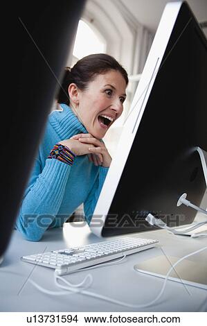 Picture - woman sitting at terminal typing. Fotosearch