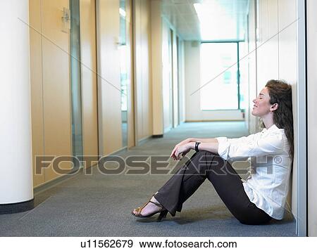 Woman sitting on the floor, at work View Large Photo Image Stock Photo - Woman sitting on the floor, at work. Fotosearch