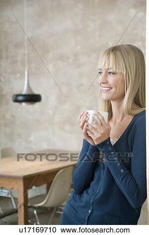 Stock Image - woman smiling and holding cup. Fotosearch