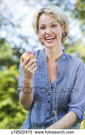 woman smiling holding apple View Large Photo Image Stock Image - woman smiling holding apple. Fotosearch