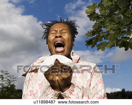 Stock Photo - woman sneezing outside. Fotosearch