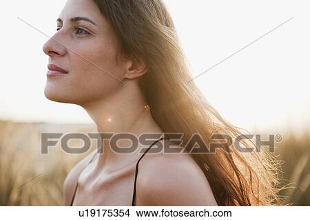 Picture - woman strolling through reed. Fotosearch