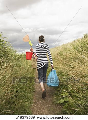 Woman walking down path View Large Photo Image Stock Photo - Woman walking down path. Fotosearch