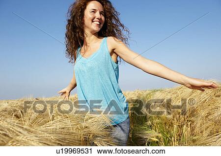 Woman walking in a wheat field View Large Photo Image Stock Image - Woman walking in a wheat field. Fotosearch