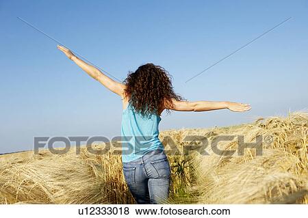 Woman walking in a wheat field View Large Photo Image Stock Photo - Woman walking in a wheat field. Fotosearch