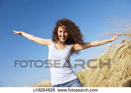 Stock Photograph - Woman walking in a wheat field. Fotosearch