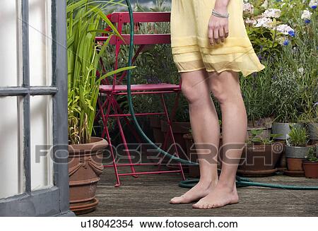 woman watering plants on balcony View Large Photo Image Picture - woman watering plants on balcony. Fotosearch