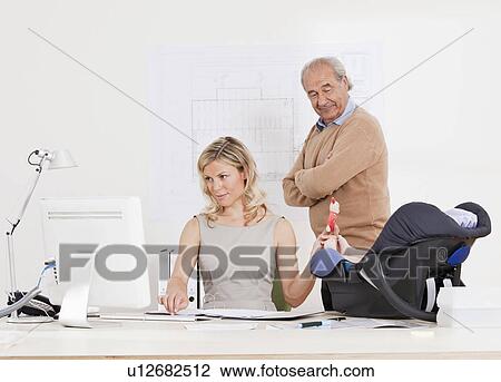 Stock Image - Woman with baby, boss watching her.. Fotosearch