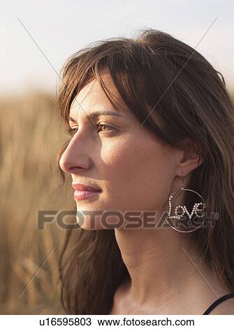 Stock Image - woman with earring standing in the reed. Fotosearch