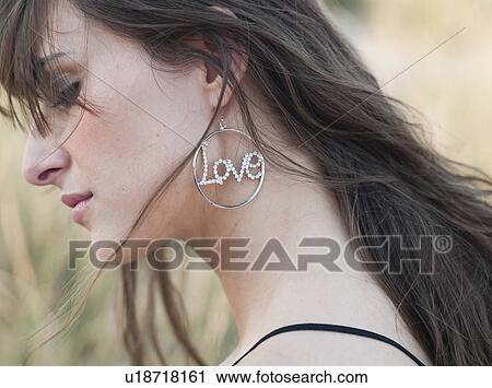 Stock Image - woman with earring walking through reed. Fotosearch