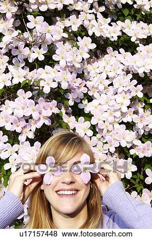 Woman with flowers before her eyes View Large Photo Image Stock Photo - Woman with flowers before her eyes. Fotosearch