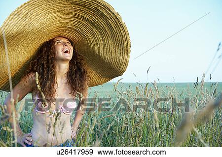 Stock Photo - Woman with hat, in a wheat field. Fotosearch