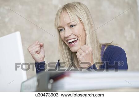 Stock Image - woman with laptop cheering. Fotosearch