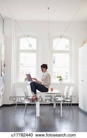 woman with laptop sitting on table View Large Photo Image Stock Image - woman with laptop sitting on table. Fotosearch