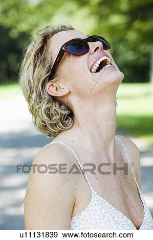 Stock Photo - woman with sunglasses laughing. Fotosearch
