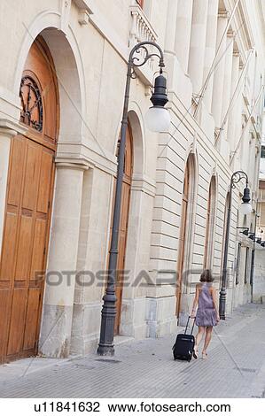 woman with trolly walking along street View Large Photo Image Stock Image - woman with trolly walking along street. Fotosearch