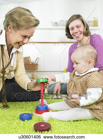 Stock Photograph - Women and baby playing together. Fotosearch
